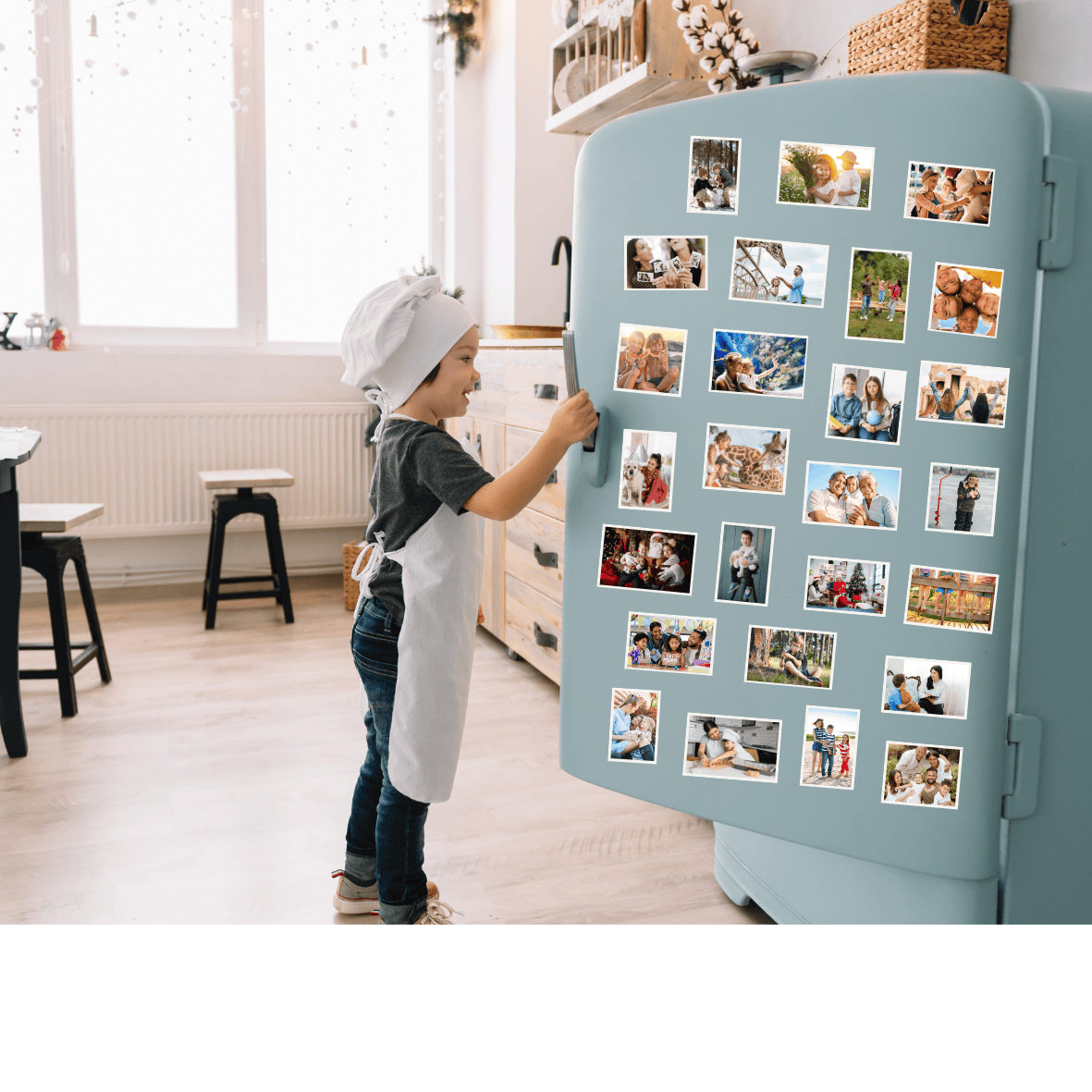 A little boy with a chef hat and apron opening fridge door with lots of vibrant photo magnets displayed on it